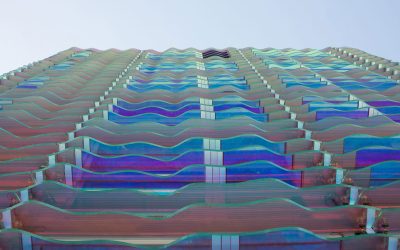 Un hotel mirando al océano con una matriz de lamas de vidrio como piel